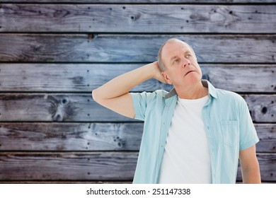 Thoughtful Older Man Looking Up Against Grey Wooden Planks