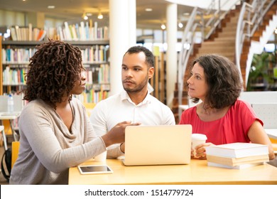 Thoughtful people talking while using laptop at library. Three students preparing to lesson. Education concept - Shutterstock ID 1514779724