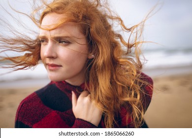 Thoughtful redhead woman standing in the beach - Powered by Shutterstock