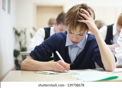 Thoughtful School Boy Struggling To Finish Test In Class.