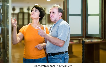 Thoughtful Senior Couple Examining Objects Applied Art On Expositions In Museum