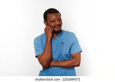 Thoughtful Surgeon Doctor Bearded Man In Blue Coat Isolated On White Background. Brooding Adult Black African American Practicing Surgeon Portrait, Pensive Look