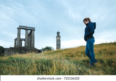 Thoughtful tourist woman standing at the Roman Cramond Fort in Edinburgh, Scotland.