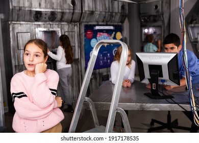 Thoughtful Tween Girl Thinking About Solving Puzzle To Get Out Of Closed Space Of Escape Room Designed As Abandoned Bunker