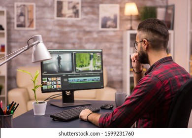 Thoughtful videographer while working in a movie on computer from home. - Shutterstock ID 1599231760