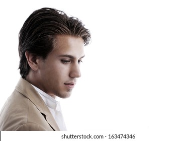 Thoughtful, Wistful Handsome Young Man In A Jacket Staring Downwards With A Serious Expression, Side View Head And Shoulder Portrait On White With Copyspace.