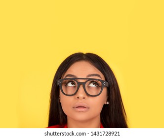 Thoughtful Woman Looking Up. Closeup Face Portrait Isolated On Yellow Background. African American Caucasian Indian Mixed Race Model Girl.