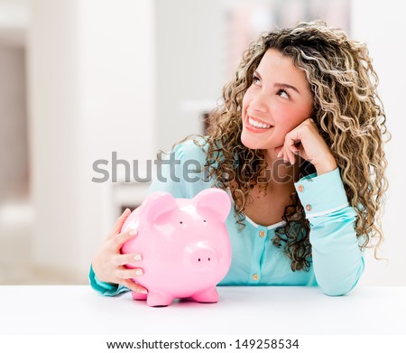Thoughtful woman with a piggybank looking very happy 