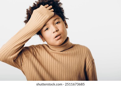 A thoughtful young african american boy in a cozy brown sweater contemplating with his hand resting on his head - Powered by Shutterstock