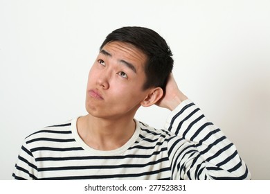 Thoughtful Young Asian Man Looking Upward.