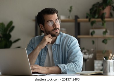 Thoughtful young business man in glasses sit at desk distracted from computer work looks into distance consider contemplate search solution or fresh creative startup ideas. Brooding, brainwork concept - Powered by Shutterstock