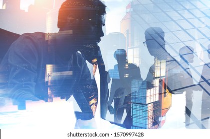 Thoughtful young CEO and blurry members of his team working together in Moscow city. Concept of leadership and collaboration. Toned image double exposure - Shutterstock ID 1570997428