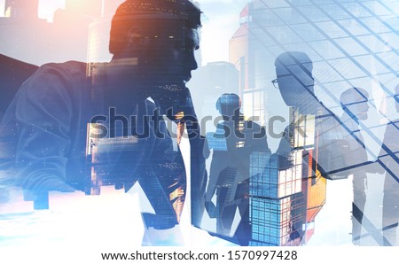 Thoughtful young CEO and blurry members of his team working together in Moscow city. Concept of leadership and collaboration. Toned image double exposure