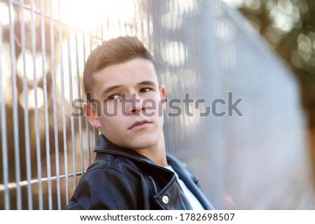 Similar – Stylish teenager sitting on a wooden bench on a city park