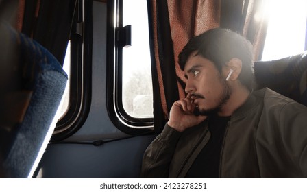 A Thoughtful young man traveling and sitting in an economy bus, with space for text - Powered by Shutterstock