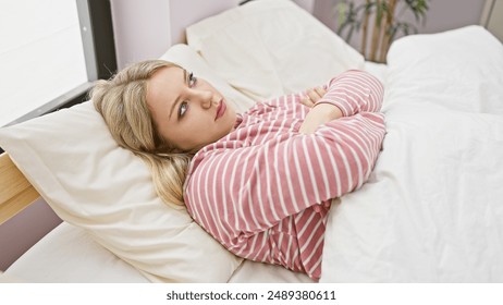 A thoughtful young woman lies in bed, gazing away in a comfortable bedroom setting, depicted in this serene portrait. - Powered by Shutterstock