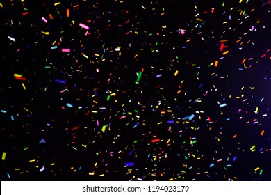 Thousands Of Confetti Fired On Air During A Festival At Night. Image Ideal For Backgrounds. Multicolor Are The Confetti In The Picture. The Sky As Background Is Black. Multicolor Tonality