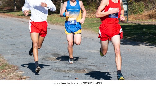 Thre High School Boys Competing In A Cross Country Running Race On A Gravel Path At Van Cortlandt Park In The Bronx.