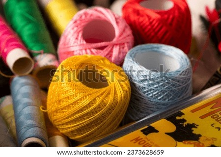 Thread box. box with sewing threads of yellow, red, blue colors in close-up with selective focus. Spools of colored needle threads messy after use. sewing equipment.
