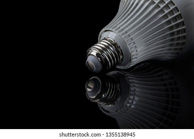 Thread of lightbulb with reflection on black background