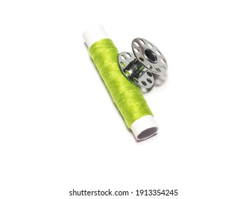 Thread And Metal Bobbin On A White Background. Sewing Machine Spool Arranged.