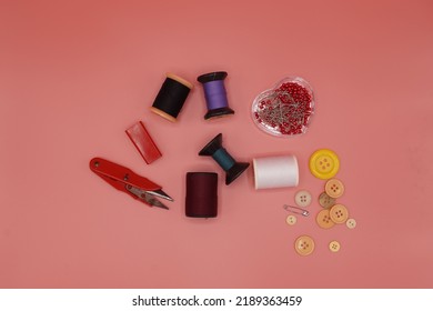 Thread, Scissors, Needle, Buttons, Sewing Accessories, Pink Ground, Isolated.top Angle,top View