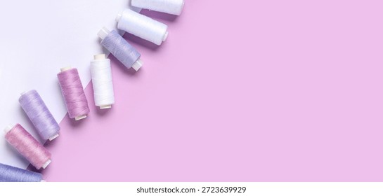Thread spools on color background with space for text, top view