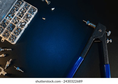Threaded Insert Riveter Gun Kit. setting tool, nosepieces and inserts, for all types of rivets, including threaded rivet nuts, pliers. black background, copy space.