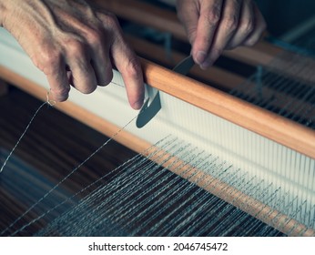 Threading the table loom using heddle hook. Woman hands hold a weaving tool. Warping a wooden handloom - Powered by Shutterstock