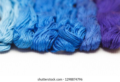 Threads of blue shades on the white canvas. - Shutterstock ID 1298874796