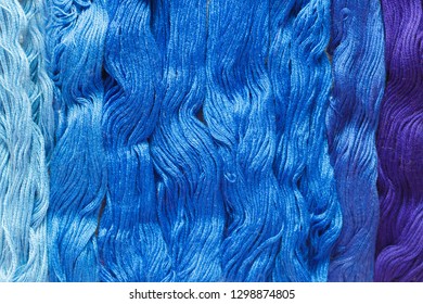 Threads of blue shades on the white canvas. - Shutterstock ID 1298874805