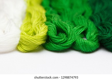 Threads of green shades on the white canvas. - Shutterstock ID 1298874793