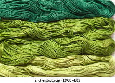 Threads of green shades on the white canvas. - Shutterstock ID 1298874862