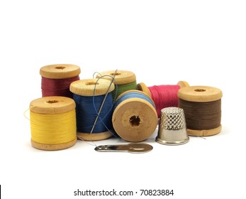 threads, needle and thimble on a white background