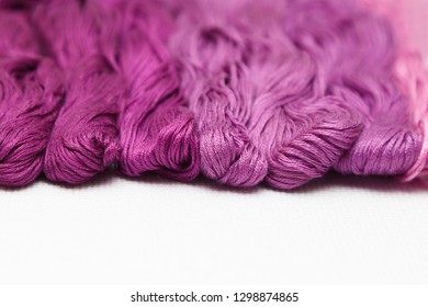 Threads of purple shades on the white canvas. - Shutterstock ID 1298874865