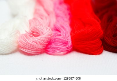Threads of red hues on a white canvas. - Shutterstock ID 1298874808