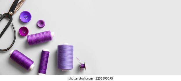 Threads with scissors and buttons on light background with space for text