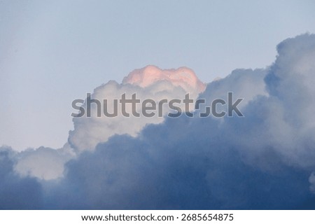 Threatening dark storm clouds with a bright pink tip over the church of St Albert in Augsburg Haunstetten