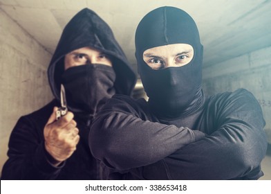 Threatening situation concept. Masked criminals. Selective focus image cross processed for dramatic look - Shutterstock ID 338653418