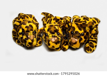 Three adorable looking stuffed leopard soft toys isolated on a plain white background
