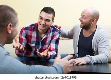 Three Adult Men Talking And Laughing At Living Room