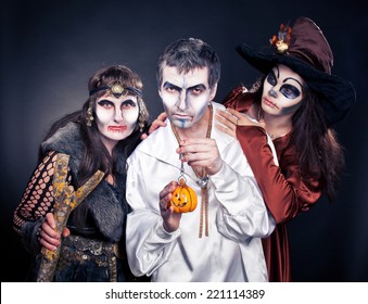 Three Adults Dressed In Halloween Costumes.