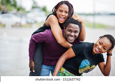 Three African American Friends Having Fun Together. Jump On Shoulder.