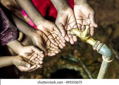 Three African Children Holding Their Hands Cupped under Water Ta