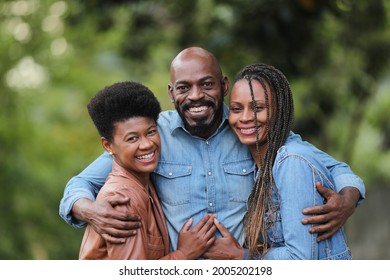 Three African Friends Smiling And Hugging Each Other