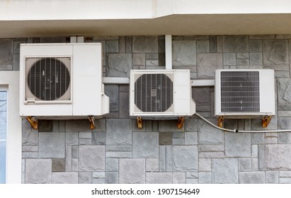 Three Air Conditioners Of Different Sizes On The Facade Of The Building