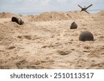 Three American infantry helmets M1 from the Second World War  on the beach.