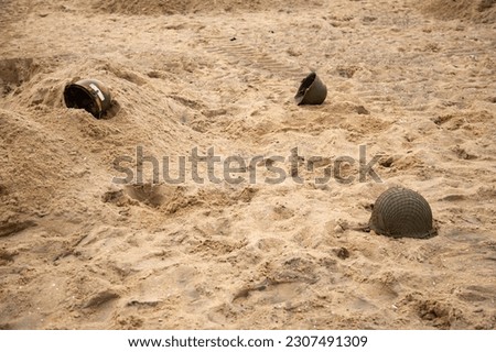 Three American infantry helmets M1 from the Second World War  on the beach. 
