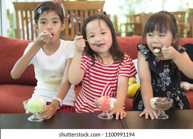 Three Asian Children Eating Ice Cream In Cafe, Family Times