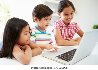 Three Asian Children Using Laptop At Home